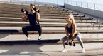 Male and female performing a dumbbell only training program outdoors on steps Male and female performing a dumbbell only training program outdoors on steps