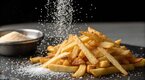 Salt poured on a pile of fries